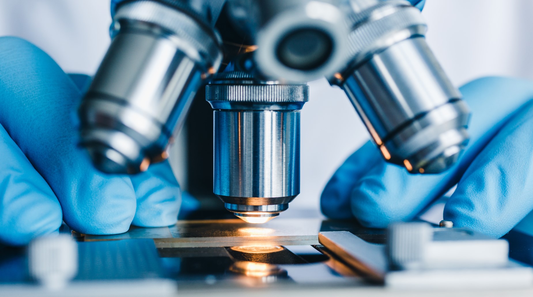 Microscope Close up photo of a person placing a slide under a microscope