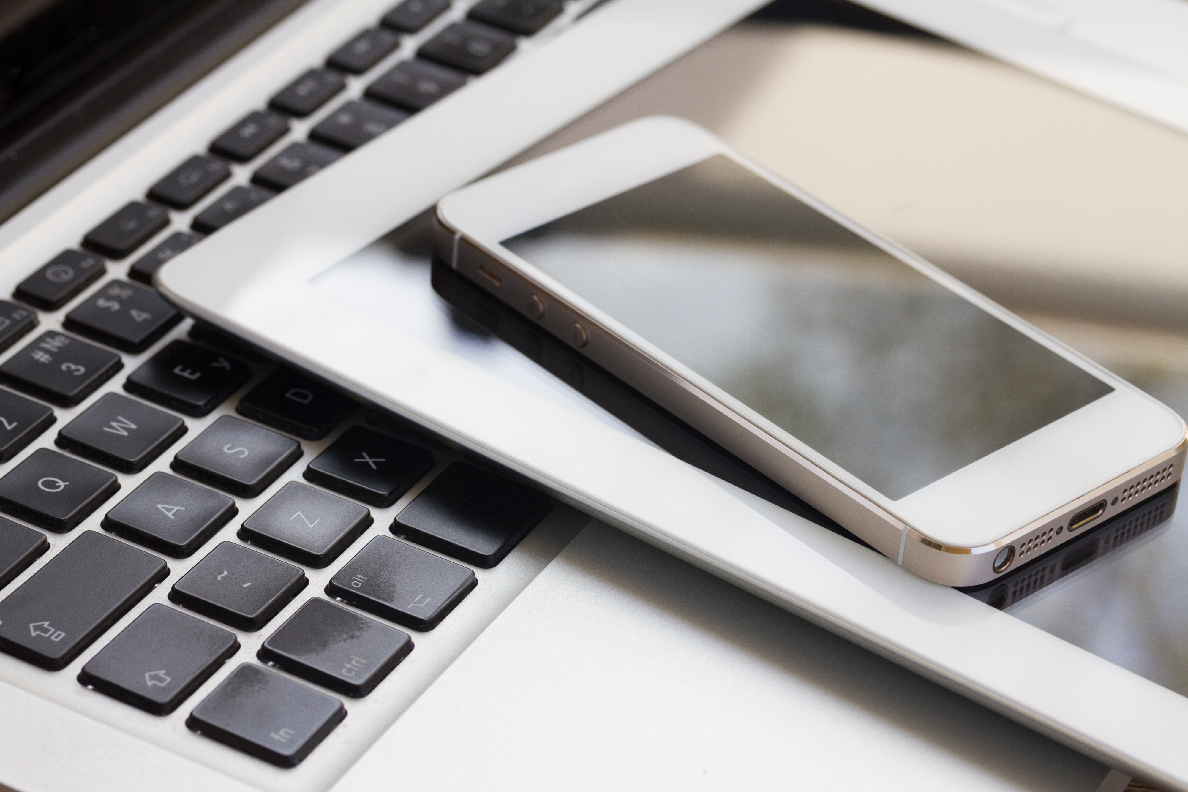 Mobile Devices A smartphone, tablet and laptop stacked onto each other