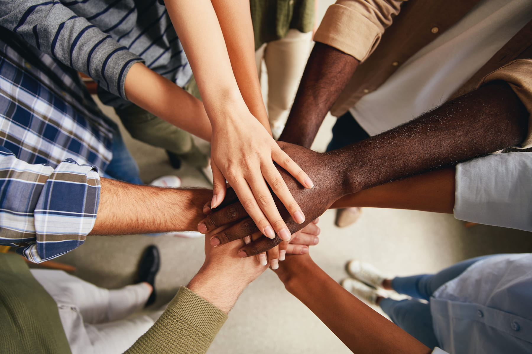 Our Culture Photo of diverse people hands put on top of each other symbolizing unity